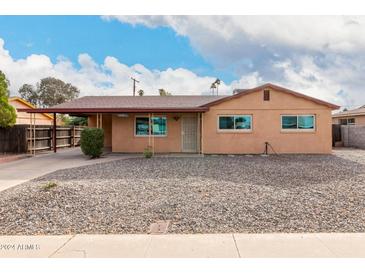 Tan single story house with carport, and rock landscaping at 2325 W Orchid Ln, Phoenix, AZ 85021