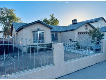 House exterior with a gated front yard and a neutral color palette at 6931 W Crittenden Ln, Phoenix, AZ 85033