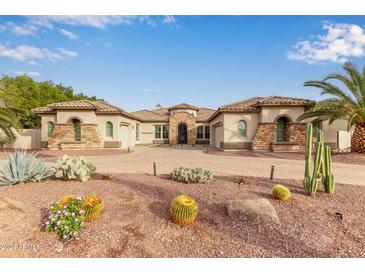 Elegant home with a brick facade, inviting entryway, and desert landscaping at 4599 N Village Pkwy, Litchfield Park, AZ 85340