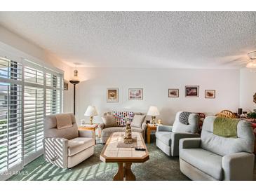 Bright and airy living room with seating and dining areas at 9277 W Jason Dr, Peoria, AZ 85382