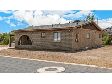 Tan brick home with carport and arched entryway at 11020 N 13Th St, Phoenix, AZ 85020