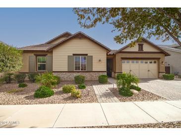 Tan house with brown accents, two-car garage, and landscaped front yard at 2595 S Jeffry St, Gilbert, AZ 85295