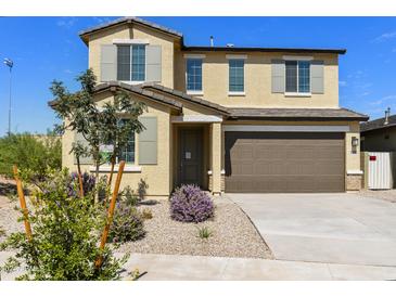 Two-story house with brown garage door and landscaping at 17332 W Corrine Dr, Surprise, AZ 85388