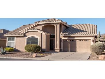 Tan two-story house with tile roof, two-car garage, and desert landscaping at 8598 E Saguaro Blossom Rd, Gold Canyon, AZ 85118