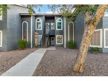 Front view of a condo building with stairs leading to the entrance, landscaping, and a tree at 255 S Kyrene Rd # 133, Chandler, AZ 85226