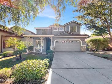 Charming two-story home with a gray exterior, landscaped front yard, and attached two-car garage at 4481 E Sundance Ct, Gilbert, AZ 85297