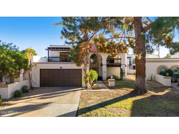 Inviting two-story home with attached garage, balcony, and landscaped front yard at 7385 E Pleasant Run, Scottsdale, AZ 85258