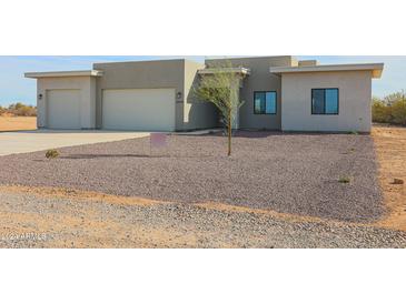 Modern single-story home with a two-car garage and gravel landscaping at 28205 N 213Th Dr, Wittmann, AZ 85361