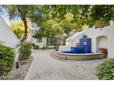 Charming courtyard with a blue tiled fountain and lush greenery at 5200 S Lakeshore Dr # 204, Tempe, AZ 85283