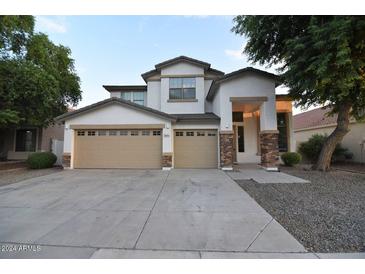 Inviting two-story home with a three-car garage and landscaped front yard at 8775 W Lane Ave, Glendale, AZ 85305