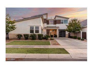 Two-story home with modern design, attached garage, and landscaped lawn at 10157 E Texas Ave, Mesa, AZ 85212