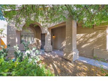 Inviting front entry with arched columns, shaded porch, and desert landscaping at 4208 E Tether Trl, Phoenix, AZ 85050
