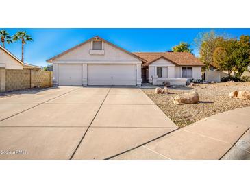 House exterior featuring a three-car garage and rock landscaping at 5606 N 75Th Dr, Glendale, AZ 85303