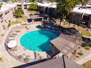 Aerial view of the community pool with lounge chairs and shade structures at 7436 E Chaparral Rd # B162, Scottsdale, AZ 85250