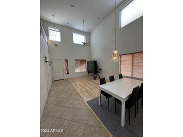 Dining room with high ceilings, wood floors, and a white dining table at 300 S 151St Ave, Goodyear, AZ 85338