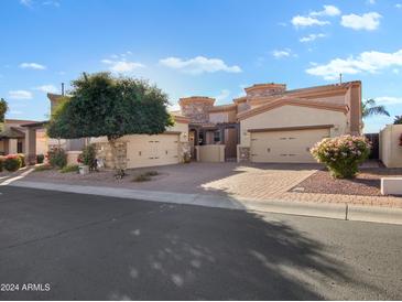 Beautiful home with a paver driveway, three-car garage, and desert landscaping at 6202 E Mckellips Rd # 66, Mesa, AZ 85215