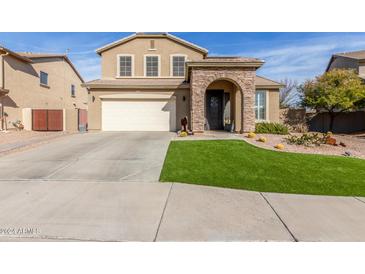 Inviting two-story home with a stone arch entryway and a well-manicured lawn at 118 W Bahamas Dr, Casa Grande, AZ 85122