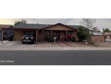 Tan house with a carport and landscaping at 3630 N 86Th Ave, Phoenix, AZ 85037