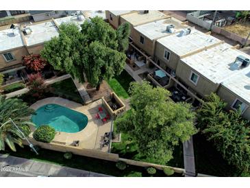 Inviting community pool, surrounded by lush trees and townhomes at 4601 N 73Rd St # 6, Scottsdale, AZ 85251