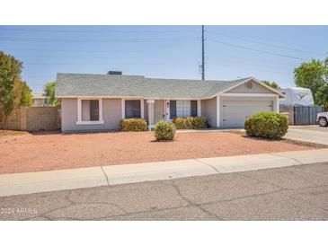 Single-story home with a two-car garage and desert landscaping at 7221 W Caron Dr, Peoria, AZ 85345