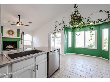 Bright kitchen with white cabinets, stainless steel appliances, and a view to the backyard at 1714 E Behrend Dr, Phoenix, AZ 85024