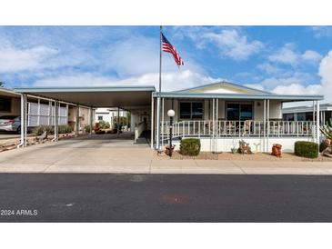 Inviting manufactured home with covered carport and landscaped front yard at 2233 E Behrend Dr # 146, Phoenix, AZ 85024