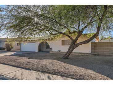 Charming single-story home with a two-car garage, gravel landscaping, and a mature tree at 4716 S Taylor Dr, Tempe, AZ 85282