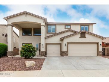 Inviting two-story home with a three-car garage and desert landscaping at 15835 W Desert Mirage Dr, Surprise, AZ 85379