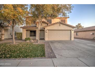 Inviting two-story home with a two-car garage and landscaped front yard at 7279 S Morning Dew Ln, Buckeye, AZ 85326