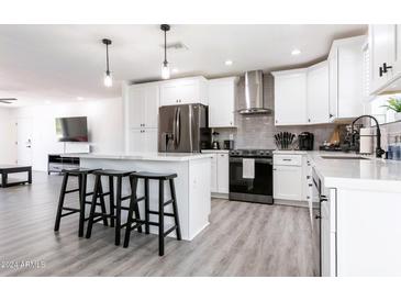 Stylish kitchen with white cabinetry, stainless steel appliances, and an island with bar stools at 2041 E Harvard Dr, Tempe, AZ 85283
