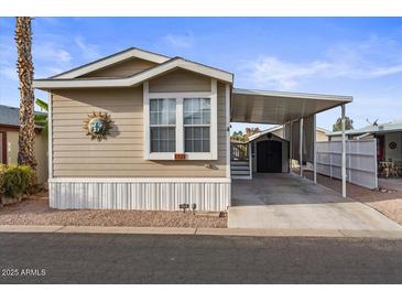 Tan single-wide manufactured home with carport and storage shed at 8865 E Baseline Rd # 1129, Mesa, AZ 85209