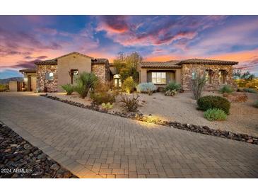 Inviting desert landscape home exterior with paver driveway at sunset at 9936 E Winter Sun Dr, Scottsdale, AZ 85262