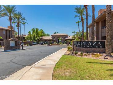 The Plaza Residences entrance with gated access, landscaping, and fountain at 7009 E Acoma Dr # 1135, Scottsdale, AZ 85254