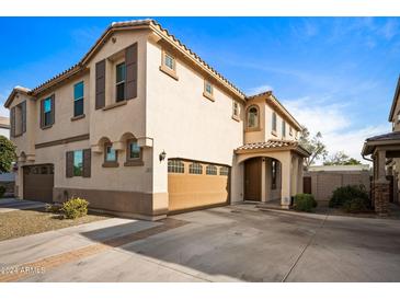 Two-story house with tan exterior, brown garage door, and a paved driveway at 2339 E University Dr # 17, Mesa, AZ 85213