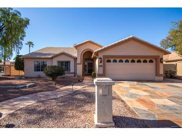 Front exterior of a single-story home with a two-car garage and landscaped yard at 4010 N 156Th Ln, Goodyear, AZ 85395