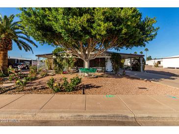Charming single-story home with lush landscaping and a covered carport at 5502 E Baywood Ave, Mesa, AZ 85206