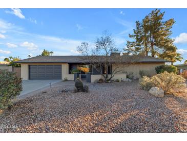 Single-story home with desert landscaping and a two-car garage at 6439 E Presidio Rd, Scottsdale, AZ 85254