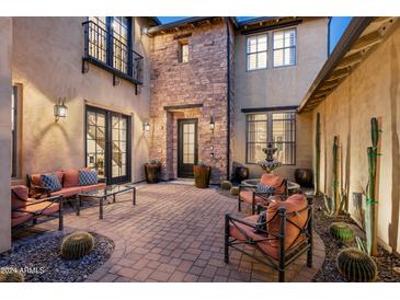 Inviting courtyard with a stone fountain, comfortable seating, and desert landscaping at 9424 E Hidden Spur Trl, Scottsdale, AZ 85255