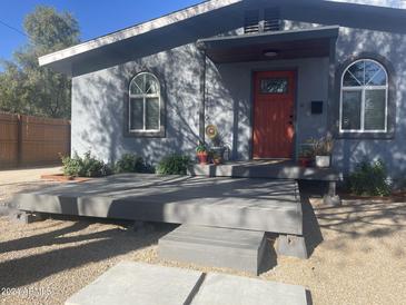 House exterior featuring a gray facade, red door and a spacious deck at 1410 E Earll Dr, Phoenix, AZ 85014