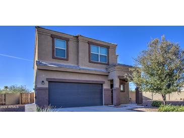 Two-story house with a large dark gray garage door and landscaping at 4689 E Argentite St, San Tan Valley, AZ 85143
