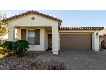 One-story home with brown garage door and landscaped front yard at 22649 E Spyglass Blvd, Queen Creek, AZ 85142