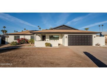 White single story home with black garage door and landscaping at 7606 N 45Th Dr, Glendale, AZ 85301