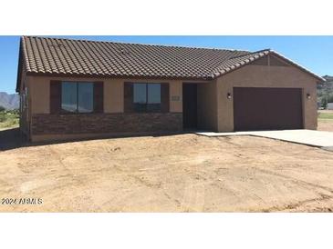 One-story home with brown roof, stone accents, and a two-car garage at 25883 W Denver Hills Dr, Wittmann, AZ 85361