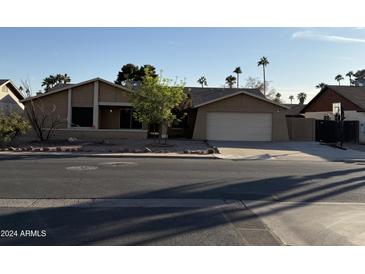 Single-story house with a two-car garage and desert landscaping at 815 W Kiva Ave, Mesa, AZ 85210