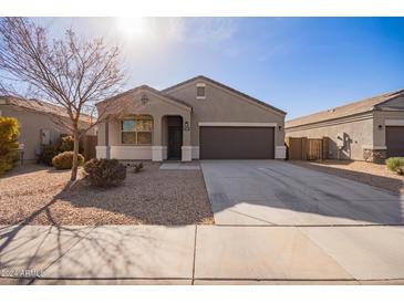 One-story house with a brown garage door and desert landscaping at 1241 E Paul Dr, Casa Grande, AZ 85122