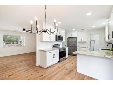 Remodeled kitchen with white cabinets, stainless steel appliances, and quartz countertops at 10404 W Audrey Dr, Sun City, AZ 85351