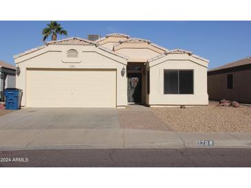 Beige house with a two-car garage and landscaped front yard at 1298 W 18Th Ave, Apache Junction, AZ 85120