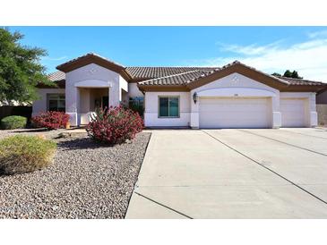 Single-story home with a three-car garage and desert landscaping at 23307 N 71St Dr, Glendale, AZ 85310