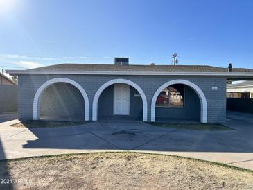 Cute ranch home with three arched entryways and a well-maintained lawn at 3441 E Taylor St, Phoenix, AZ 85008