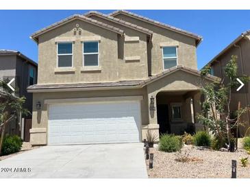 Two-story house with a white garage door and landscaping at 35262 W San Ildefanso Ave, Maricopa, AZ 85138